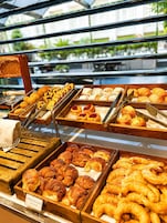 A bakery display with various baked goods, including croissants and pastries, arranged in wooden trays.