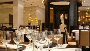 A dining area with round tables set with wine glasses, plates, and cutlery. - Regal Pacific Buenos Aires (Buenos Aires)