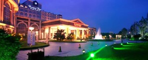 A hotel with a grand entrance, a fountain, and well-lit pathways. - Homeland Hotel (Chengdu)