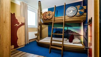 Camera con letto a castello, scala, decorazioni murali in legno e finestra con tende.