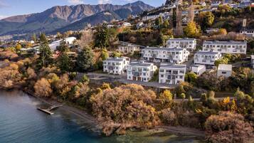 A residential area with modern houses, a clear view of the surrounding mountains, and a body of water.