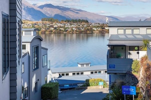 A modern building with a reception area and a view of a lake and mountains.