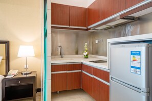 Compact kitchenette with sink, refrigerator, and telephone.