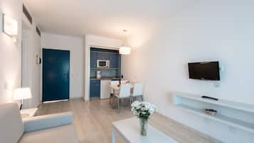 Una sala de estar moderna con un sofá, una mesa de centro y un televisor montado en la pared.