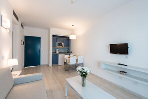 A modern living room with a sofa, a coffee table, and a TV mounted on the wall. - THB Tropical Island Aparthotel (Yaiza)