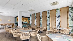 A spacious indoor dining area with wicker tables and chairs, a bar area with shelves of bottles, and a ceiling with recessed lighting. - THB Tropical Island Aparthotel (Yaiza)