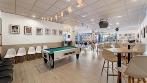 A pool table with chairs, a dining area with tables and chairs, and framed pictures on the walls. - THB Tropical Island Aparthotel (Yaiza)
