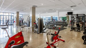 A gym with various exercise equipment, large windows, and a clean, spacious layout. - THB Tropical Island Aparthotel (Yaiza)