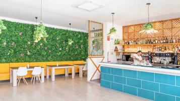 Un espace bar moderne avec un mur végétal, des sièges et un comptoir.