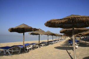 Playa privada, arena blanca, sillas reclinables de playa, sombrillas