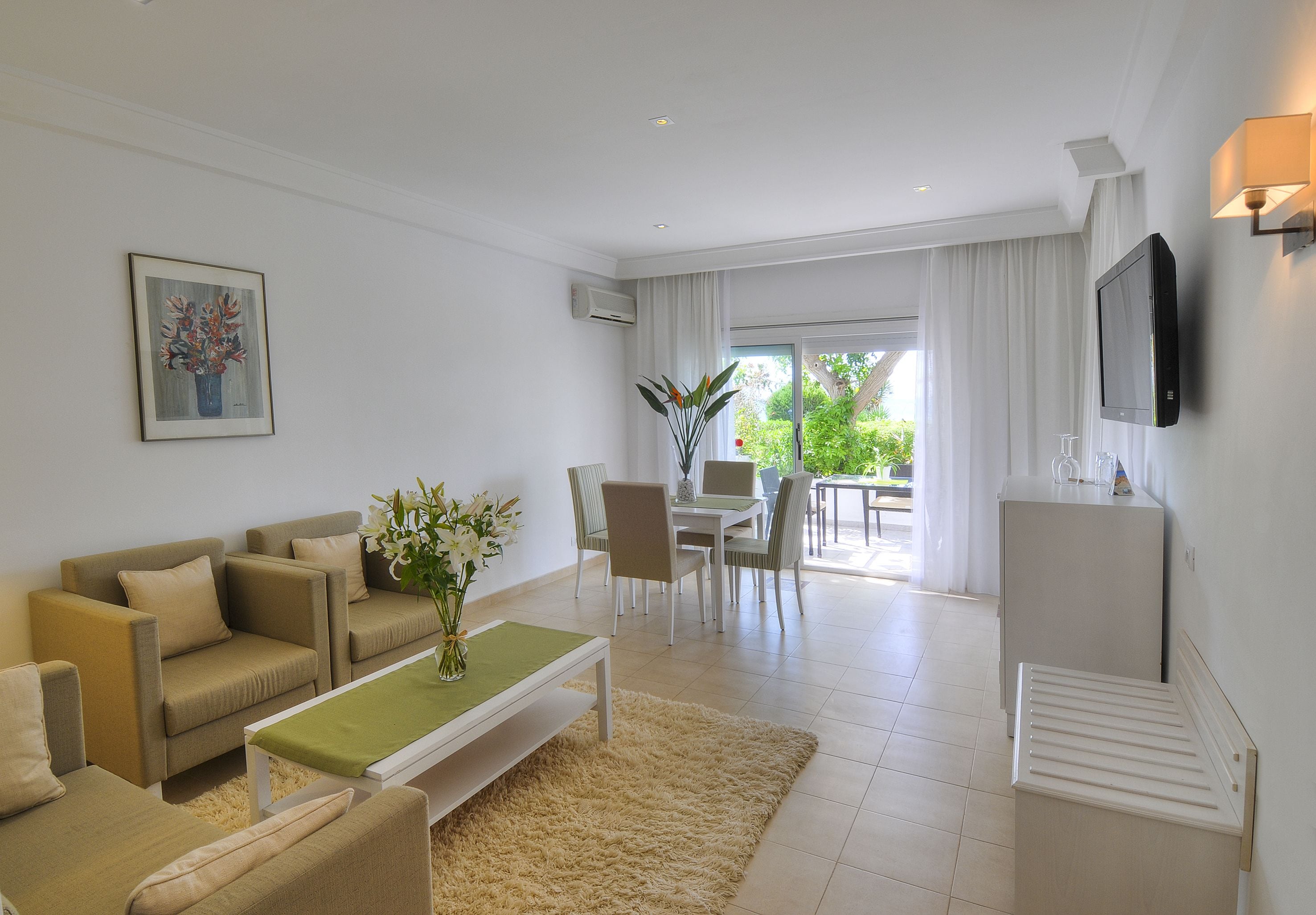 Una sala de estar moderna con un conjunto de sofá, una mesa de centro y un comedor con sillas y una mesa.
