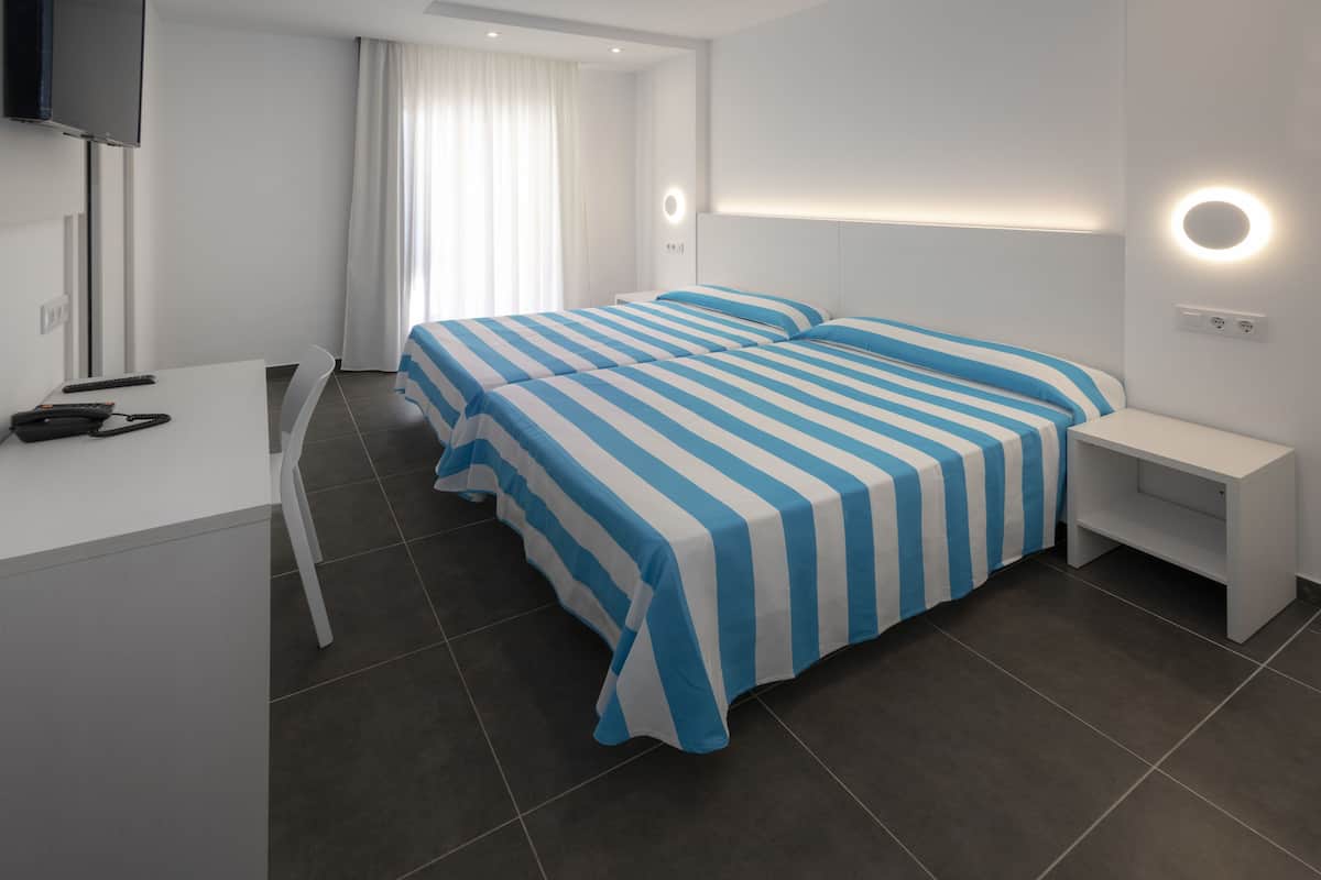 Una habitación de hotel moderna con una cama grande, un escritorio y un televisor.