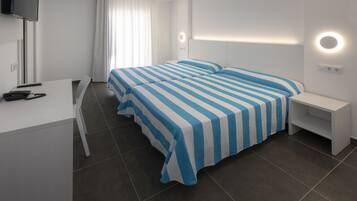 A modern hotel room with a large bed, a desk, and a TV.