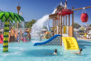 Una piscina al aire libre, sombrillas, sillones reclinables de piscina