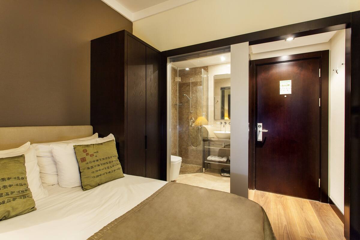 Ein Hotelzimmer mit Bett, Bad und Holzboden.
