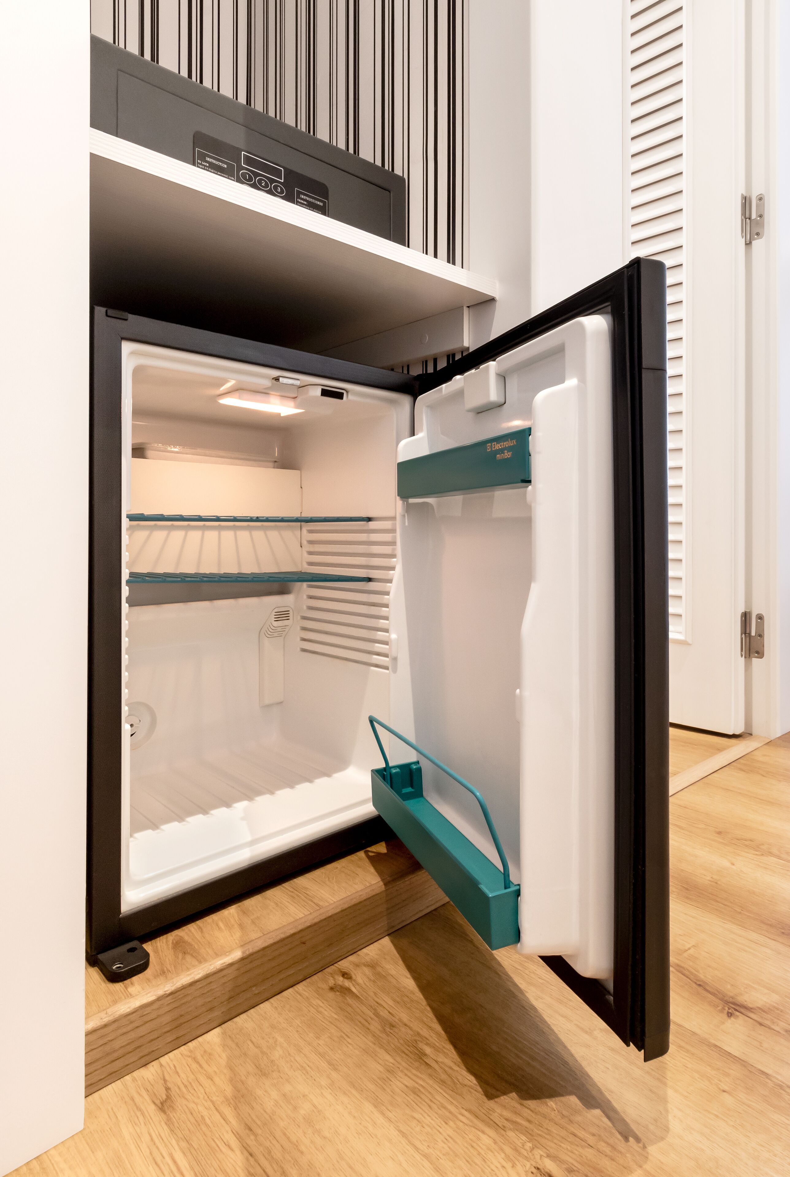 Une cuisine moderne équipée d’un réfrigérateur encastré, d’un four à micro-ondes et d’un distributeur d’eau.