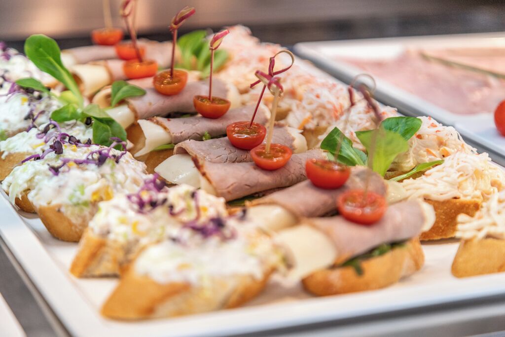 Verschiedene Vorspeisen, darunter Sandwiches, Käse und Beilagen.