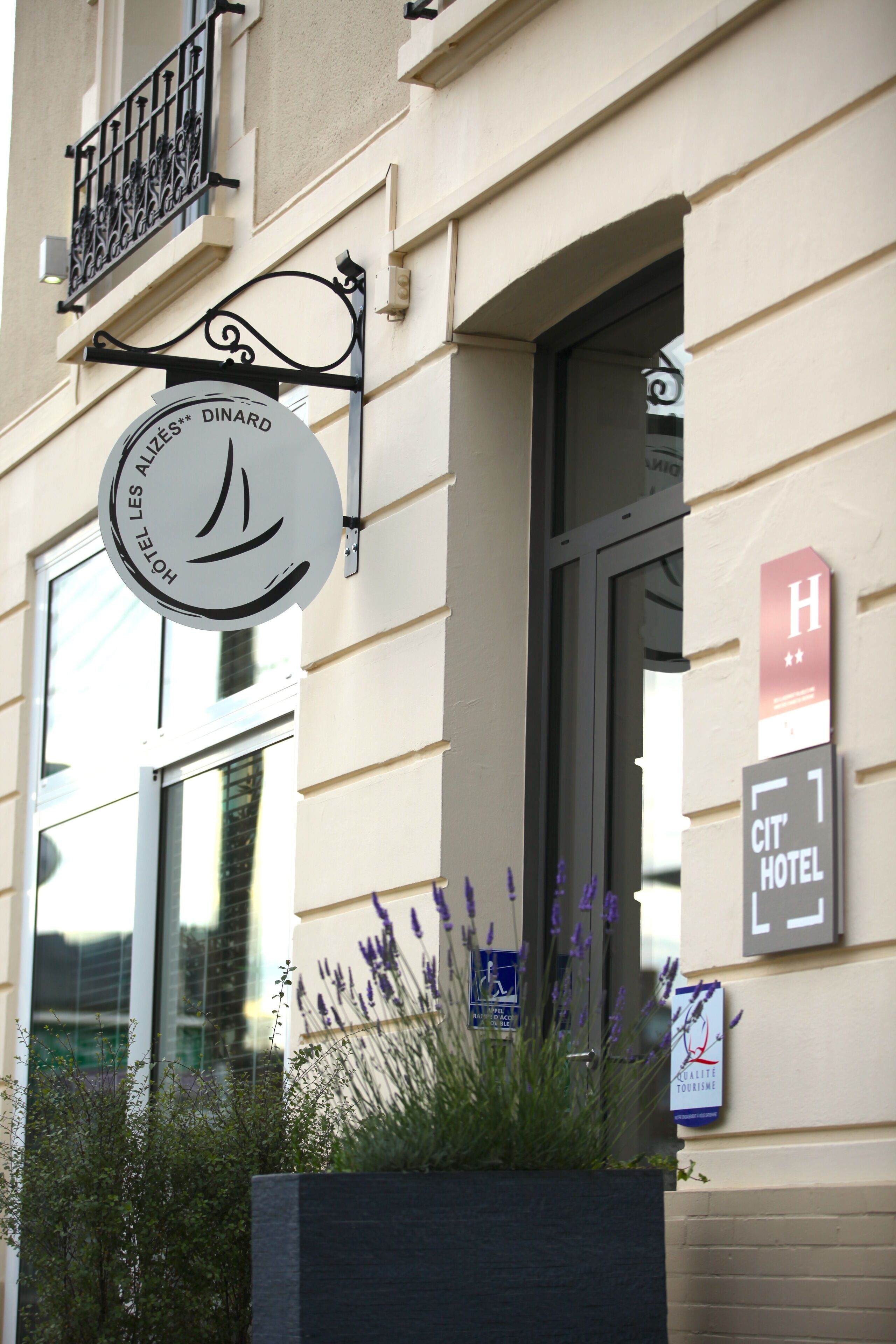 Een hotelsign met een logo van een zeilboot en de naam 'Hotel Les Alizés'.