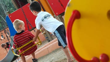 Children can play safely on the swing set and slide in this outdoor play area.