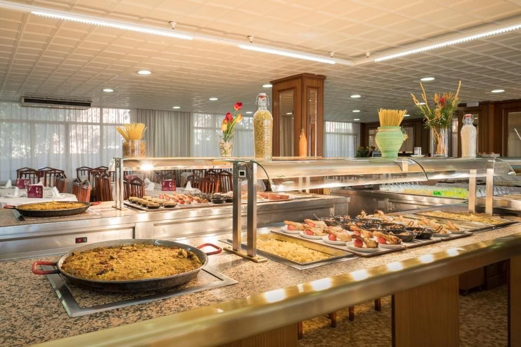Een buffet met diverse gerechten en een grote pan rijst.