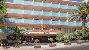 Un hotel de diseño moderno, con varios balcones y una entrada destacada.
