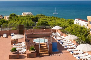 Una piscina al aire libre, sombrillas, sillones reclinables de piscina