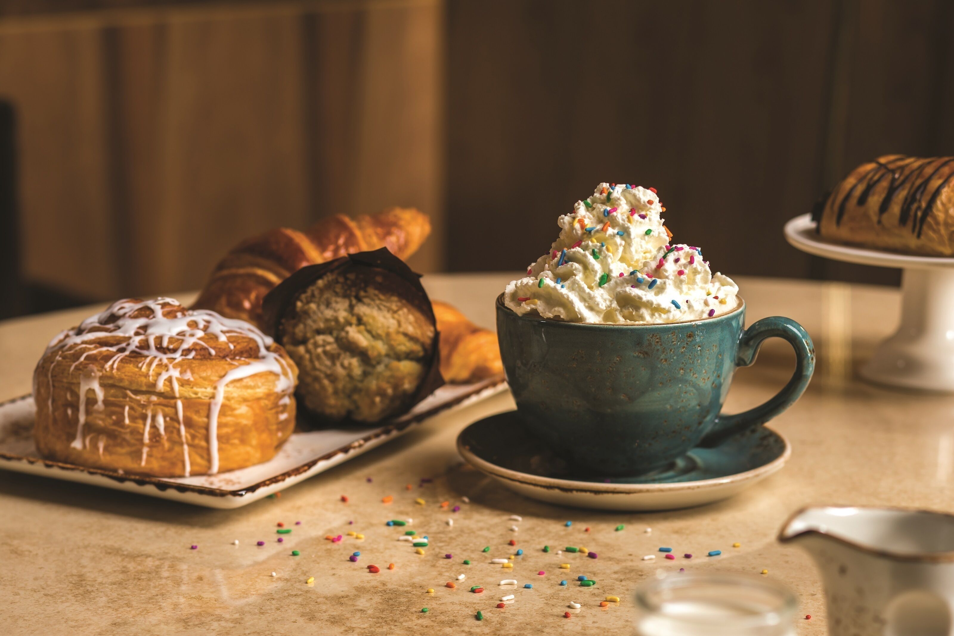 Una mesa con pasteles y una taza de café.
