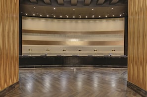 Un lobby amplio con una pared curva, un mostrador de recepción y un suelo de madera pulida.