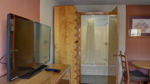 A hotel room with a wooden desk, a television, a shower with a curtain, and a chair. - The Inn At Salmon Creek (Vancouver)