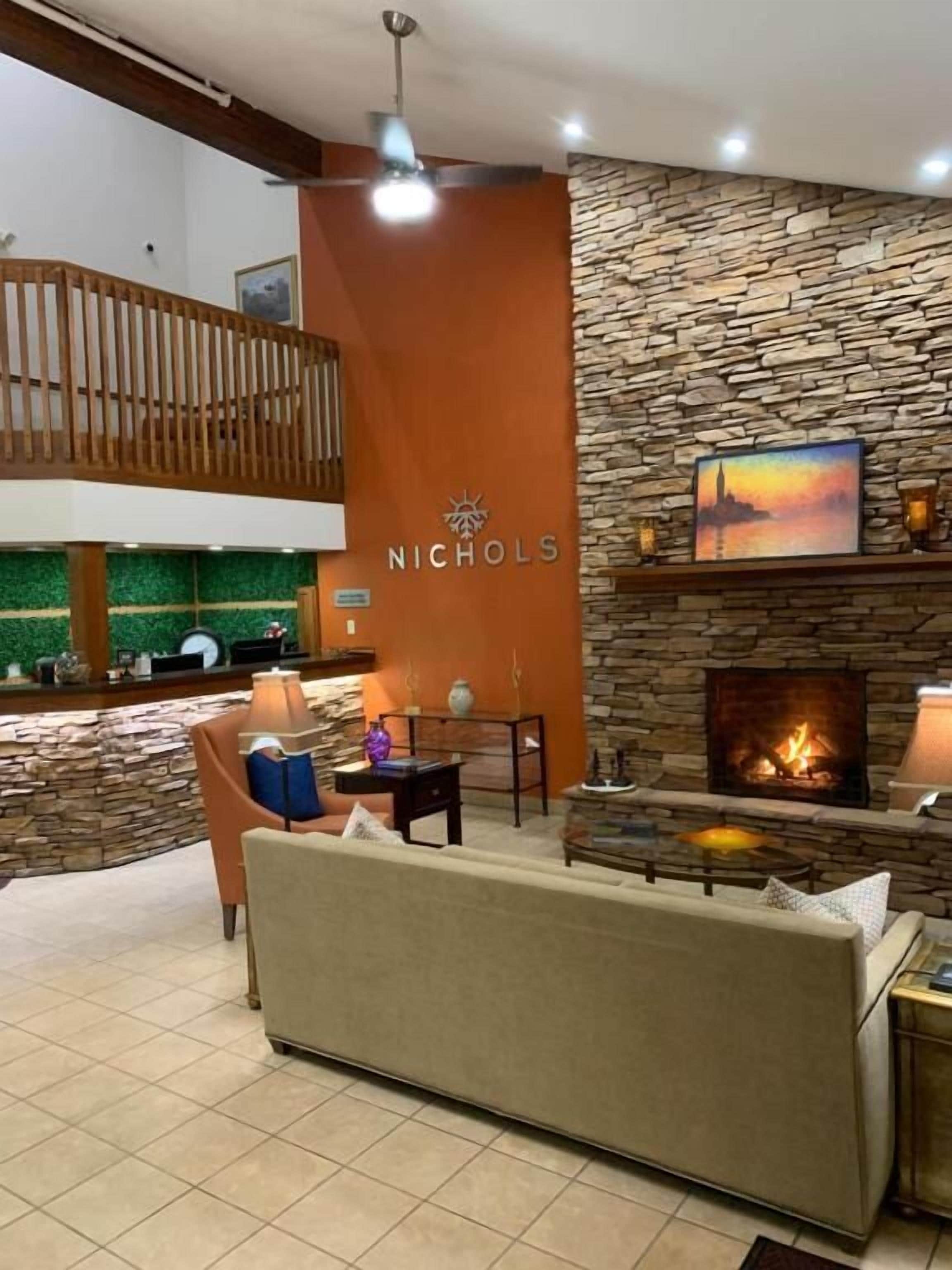 A modern lounge area with a stone wall, a fireplace, and a seating area.