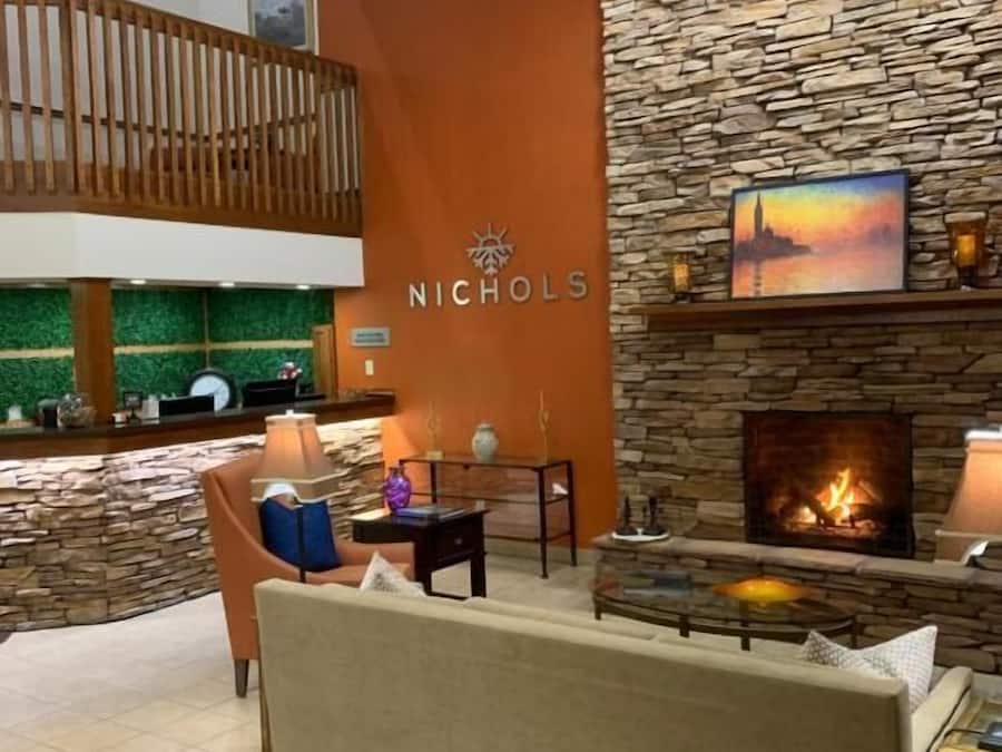 Un área de descanso moderna con pared de piedra, chimenea y zona de estar.