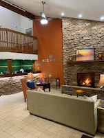 Un área de descanso moderna con pared de piedra, chimenea y zona de estar.