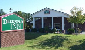 Un bâtiment en briques avec une enseigne verte sur laquelle on peut lire « Deerfield Inn ».