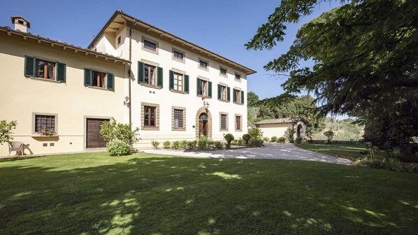 A two-story building with a symmetrical facade, multiple windows with shutters, and a central entrance with an archway. - Relais Villa Belpoggio - Residenza d'Epoca (Loro Ciuffenna)