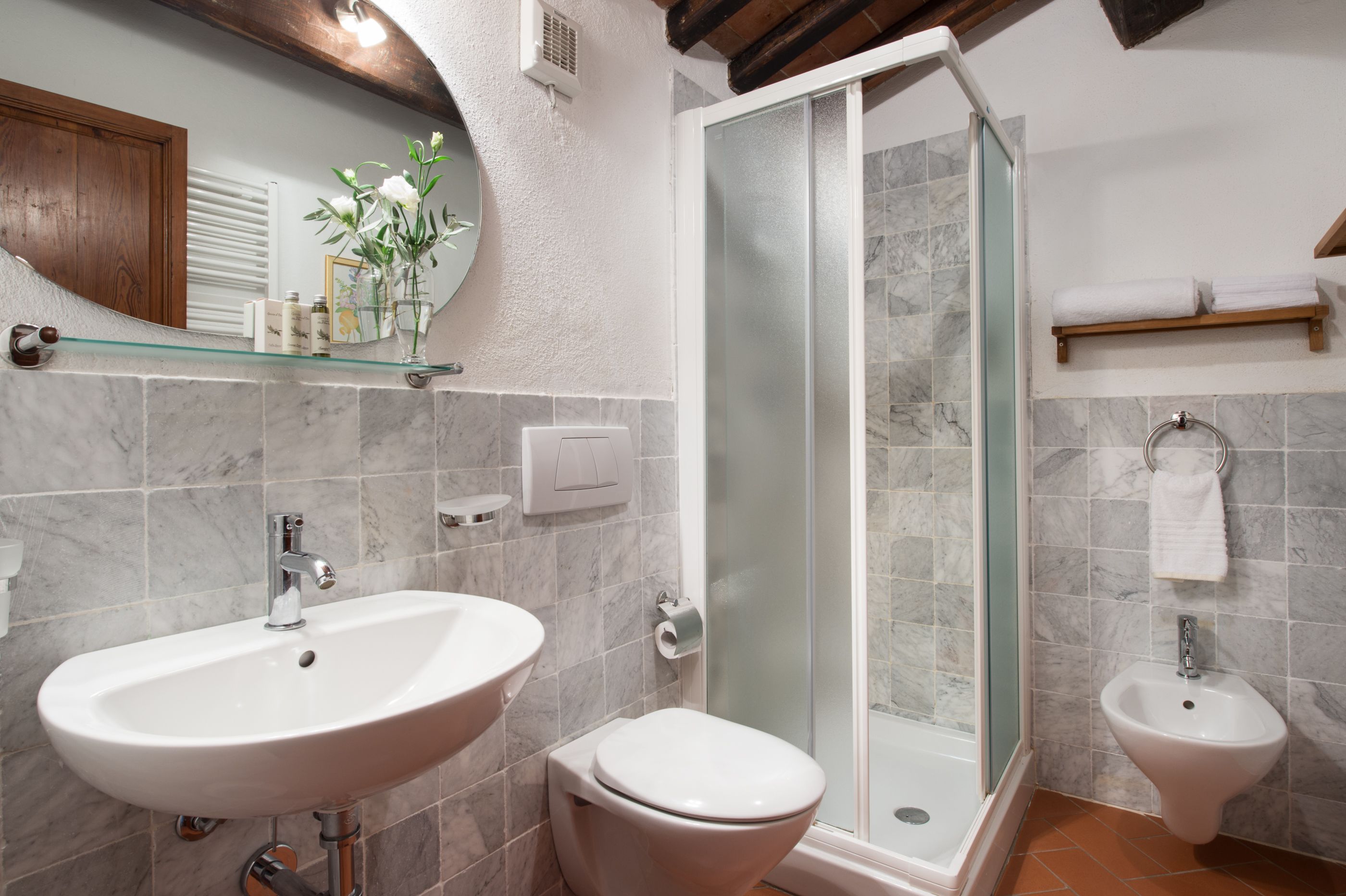 Une salle de bain avec une douche à parois de verre, un lavabo et des toilettes.