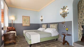 Une chambre à coucher avec un lit double, une table de chevet, une lampe, un luminaire fixé au mur et une petite table sur laquelle se trouve un vase.