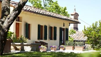 A building with a tiled roof, green shutters, and a bell tower.
