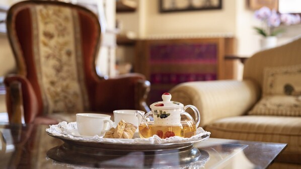A table with a teapot, cups, and biscuits.