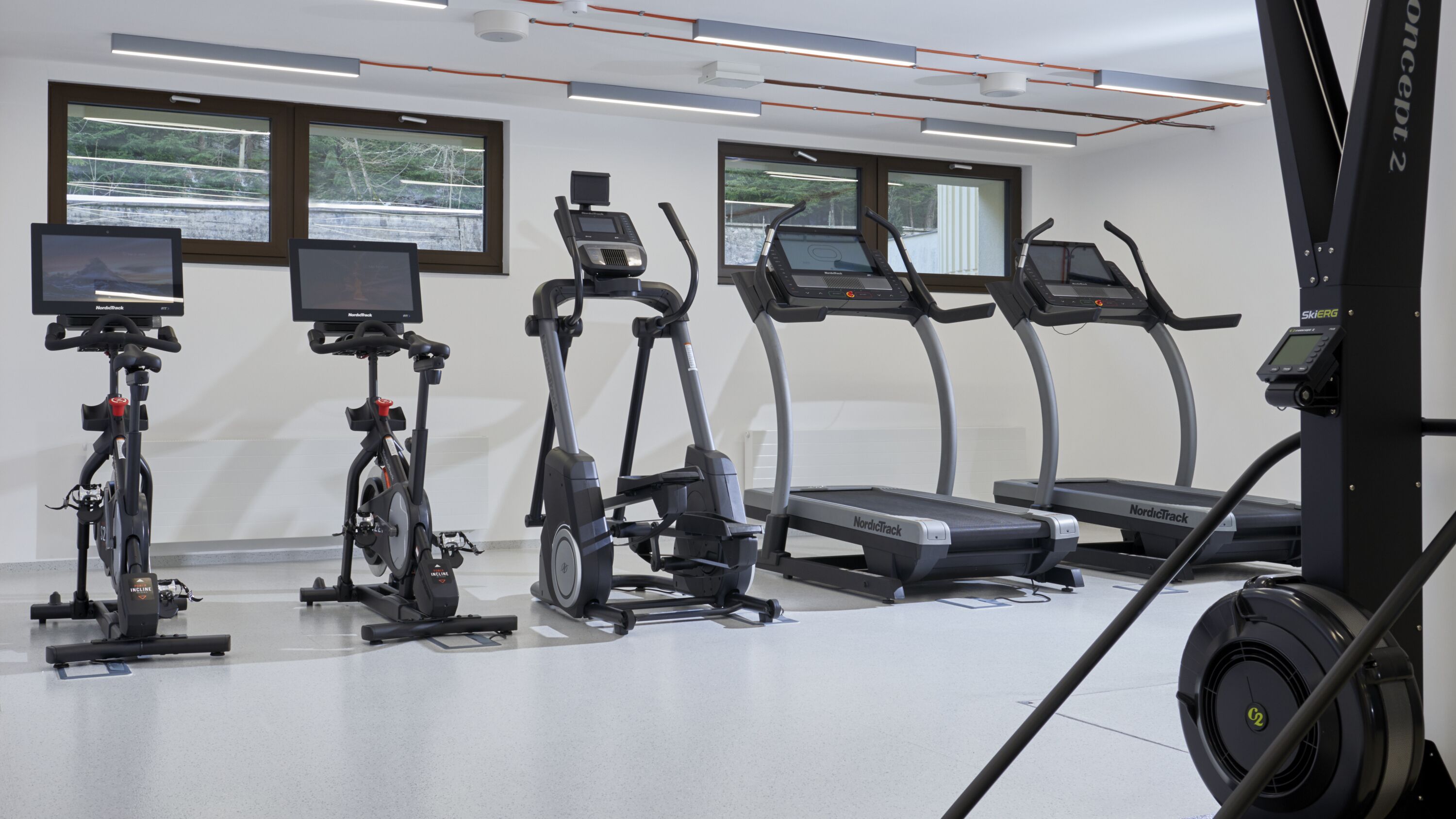 Et fitnesscenter med motionscykler, crosstrainere og løbebånd.