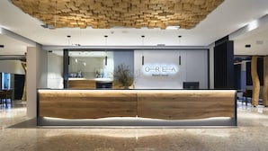 Una moderna recepción con detalles de madera y un separador de vidrio.