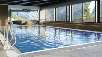 Una piscina techada, sillones reclinables de piscina