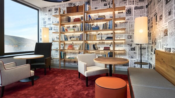 A library with bookshelves, reading chairs, and tables.