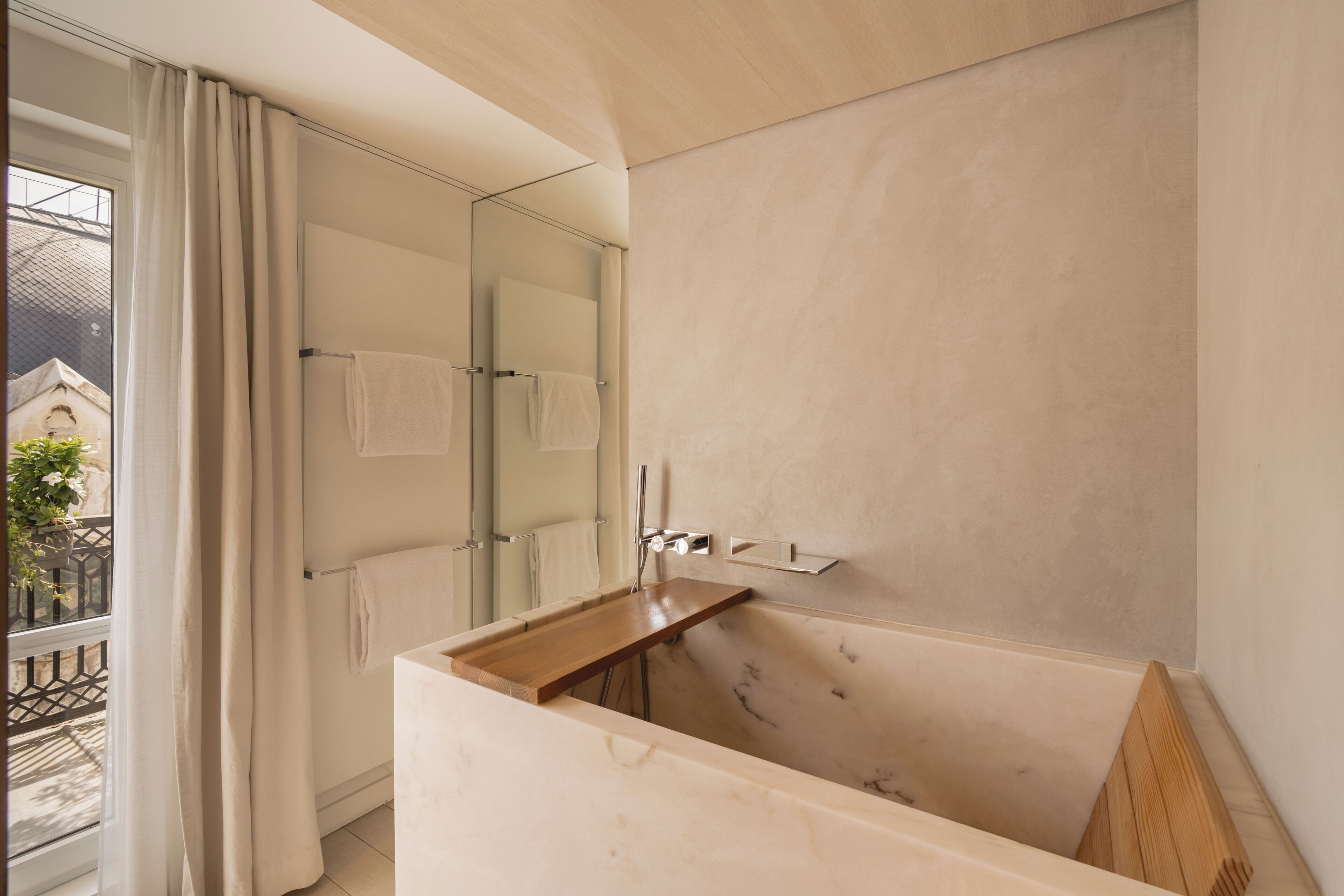 Une salle de bain moderne avec une baignoire, une cabine de douche en verre et un meuble-lavabo en bois.