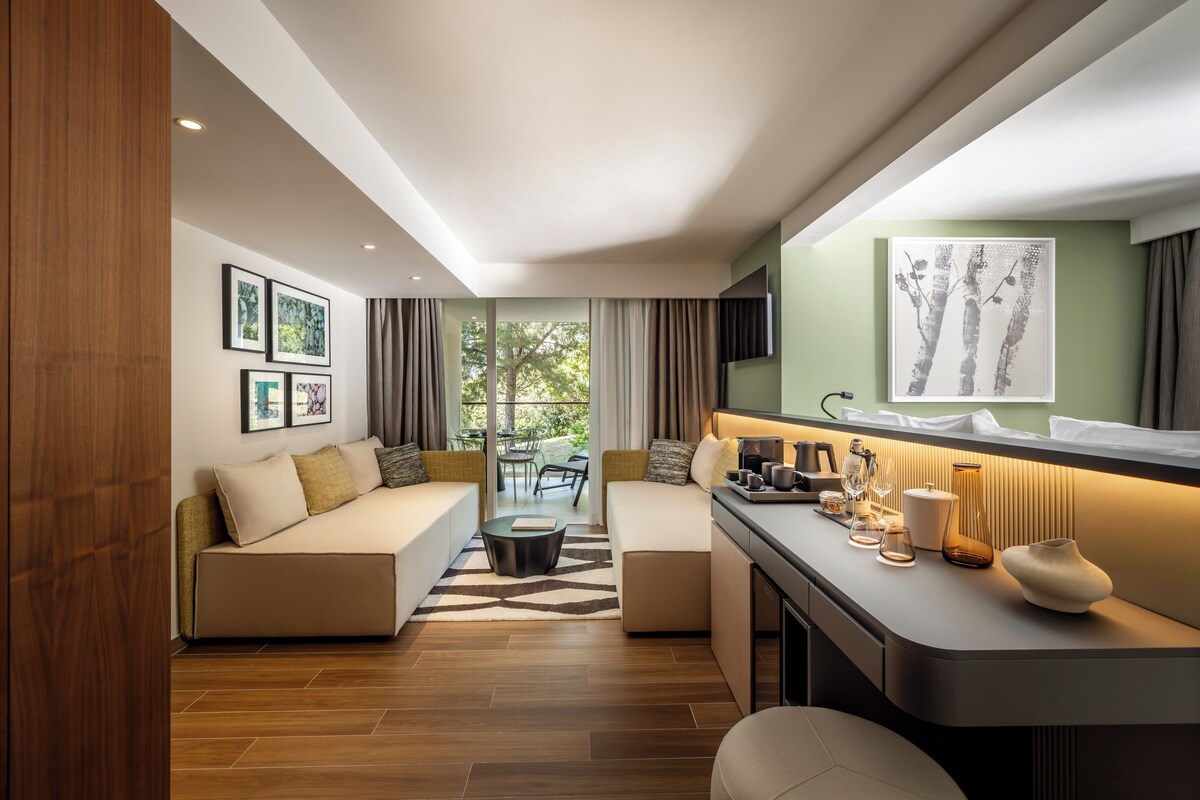 A modern living room with a sofa, a coffee table, and a dining area with a TV.