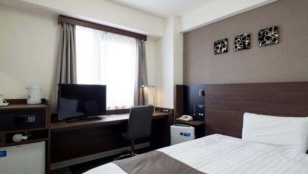 A hotel room with a bed, desk, television, and a small kitchenette. - Comfort Hotel Sakai (Sakai)