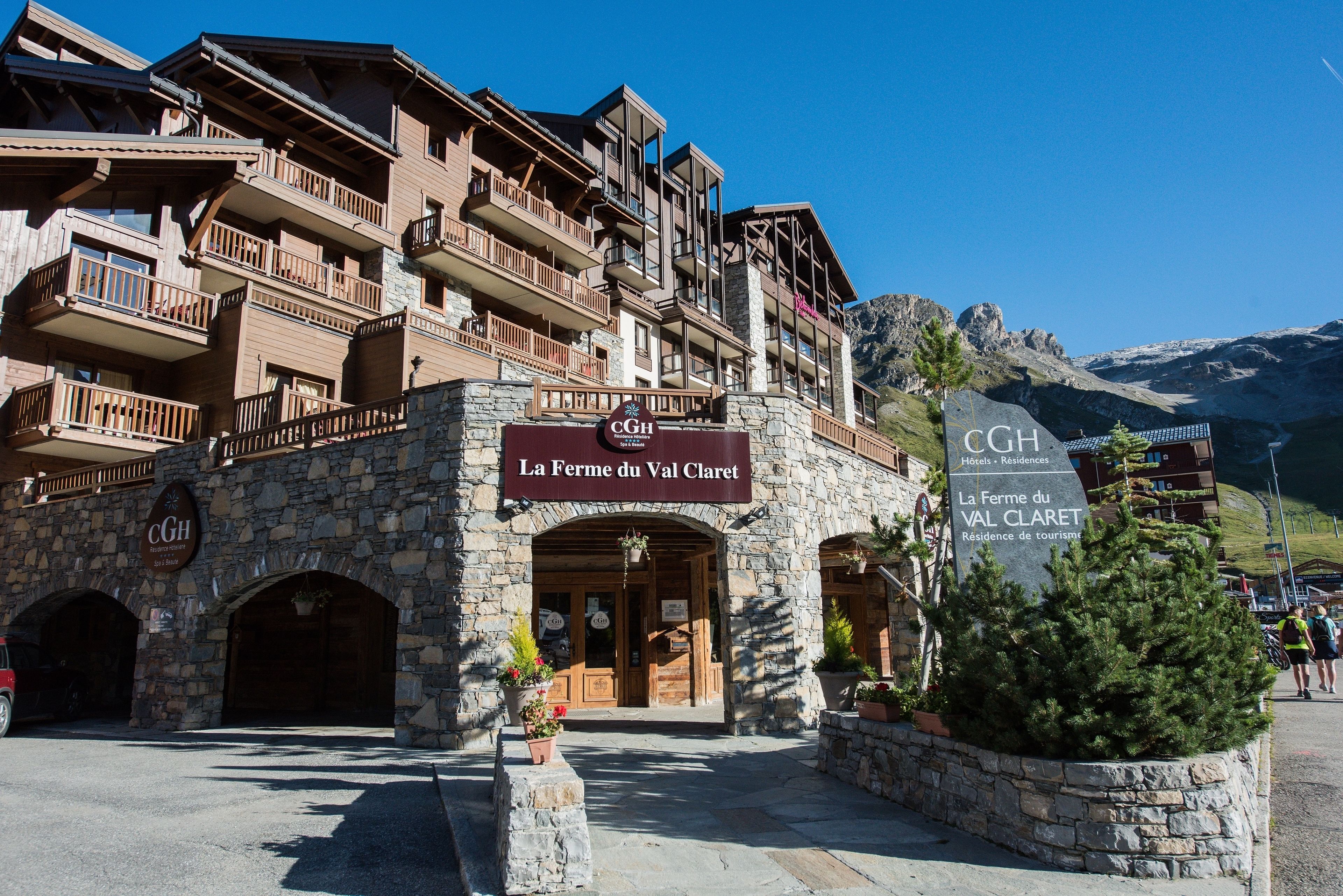 Un edificio in pietra con balconi e un cartello con la scritta 'La Ferme du Val Claret'.