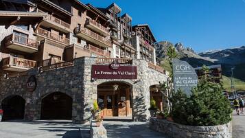 Un edificio in pietra con balconi e un cartello con la scritta 'La Ferme du Val Claret'.