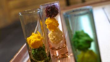 Una mesa de madera con tres vasos de vidrio transparente que contienen coloridos arreglos florales.