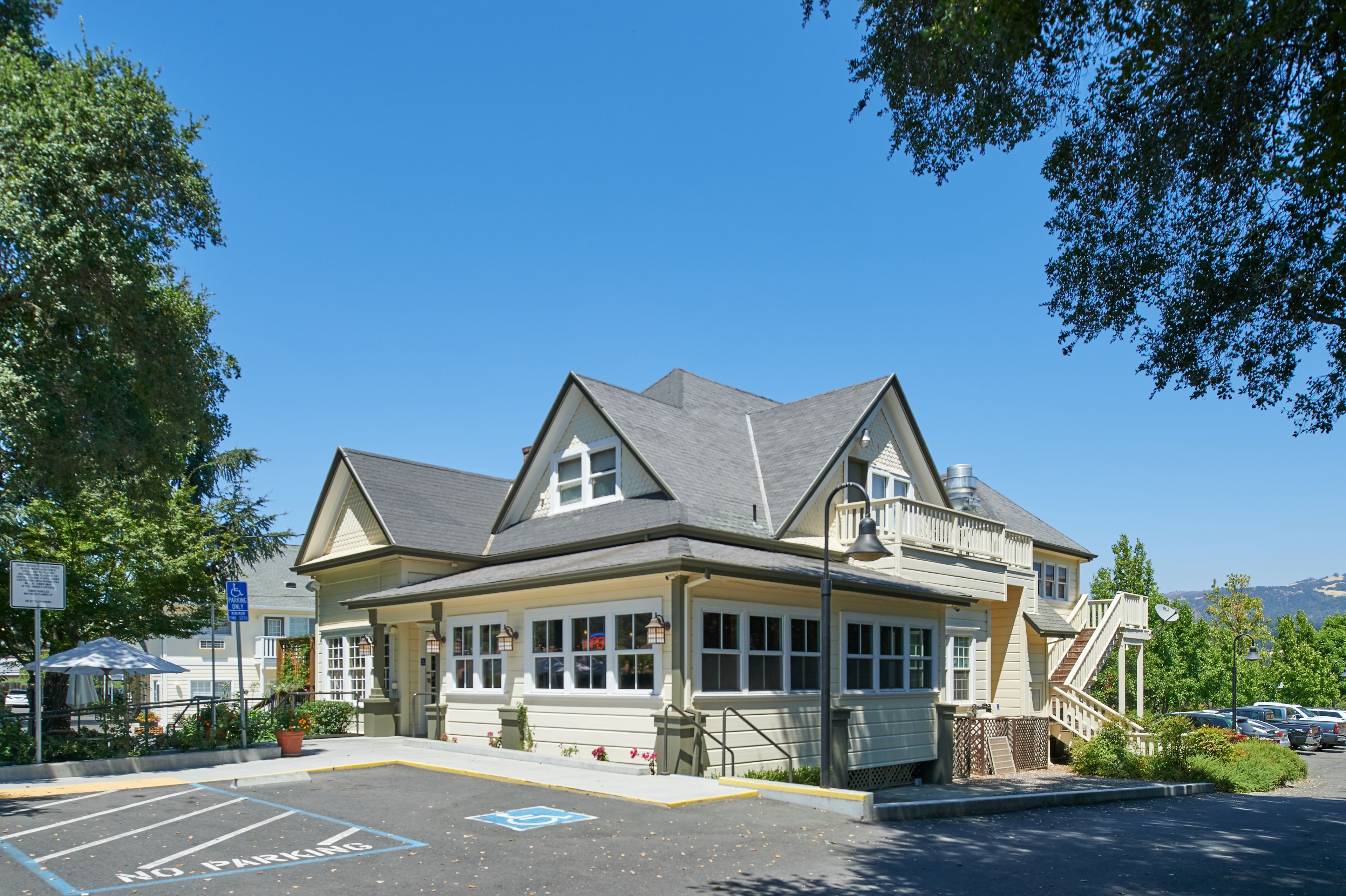 A two-story building with a gabled roof, large windows, and a wheelchair-accessible ramp.
