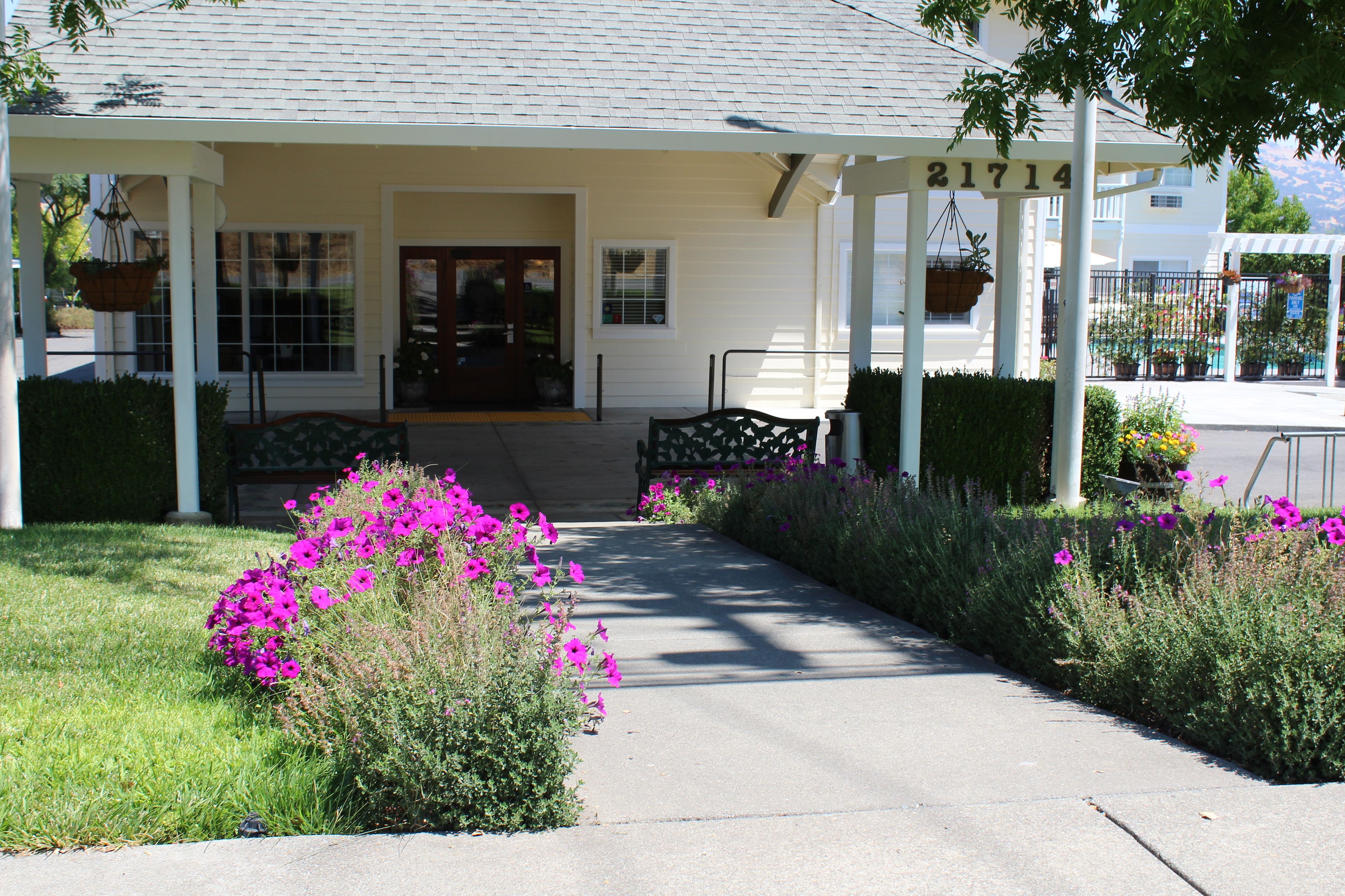 A building with a porch, a number '21714' above the entrance, and a pathway leading to the door.